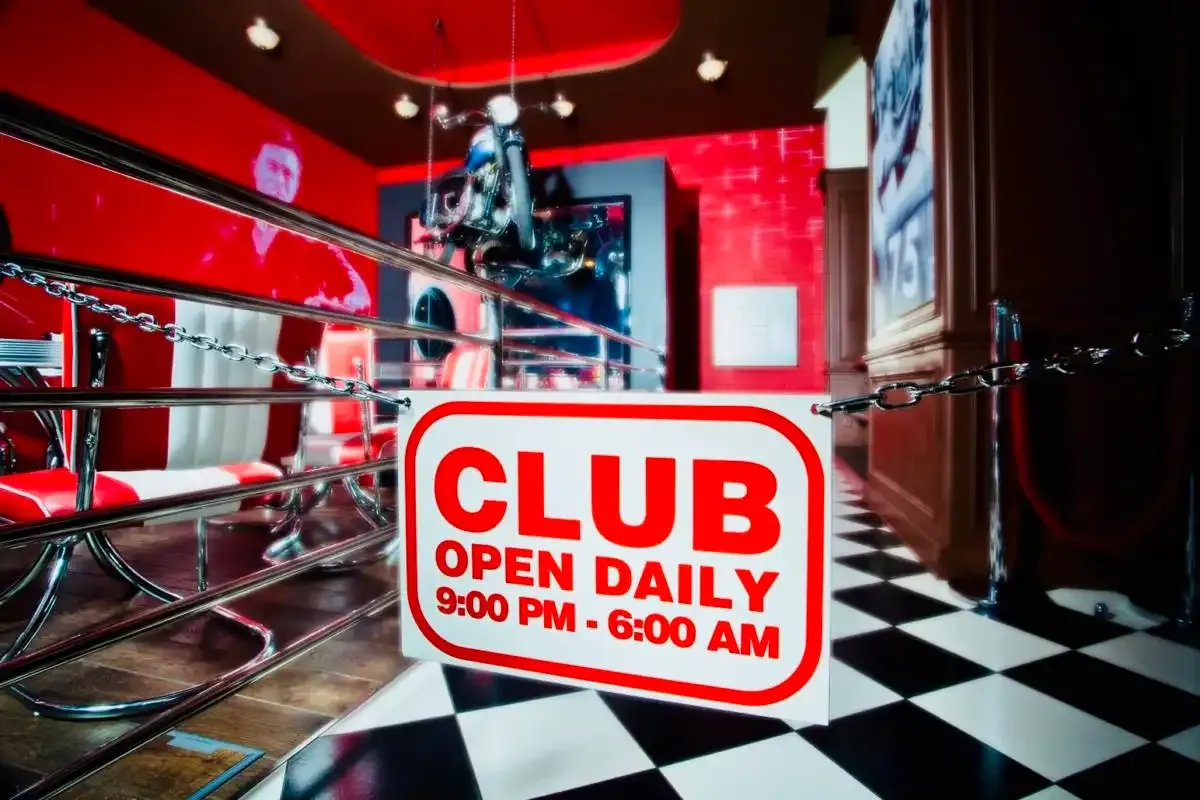 Cedule Club open daily 9:00 PM - 6:00 AM u schodiště do Music Clubu