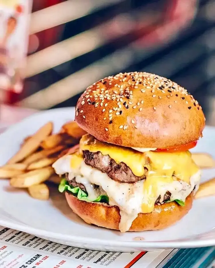 Dvojitý cheeseburger se sezamovou bulkou a hranolky