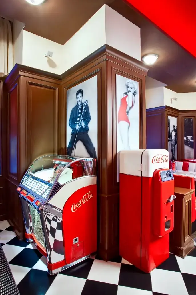 Jukebox a retro lednice Coca-Cola na šachovnicové podlaze dineru