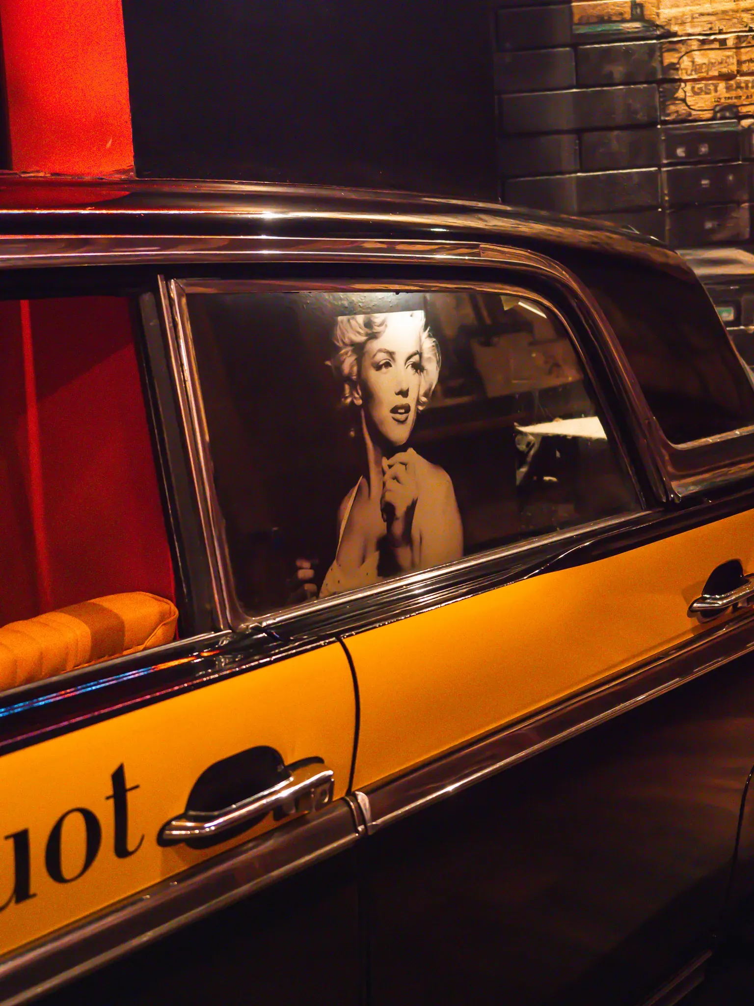 Portrét Marilyn Monroe v okně žlutého auta ve VIP zóně Music Clubu
