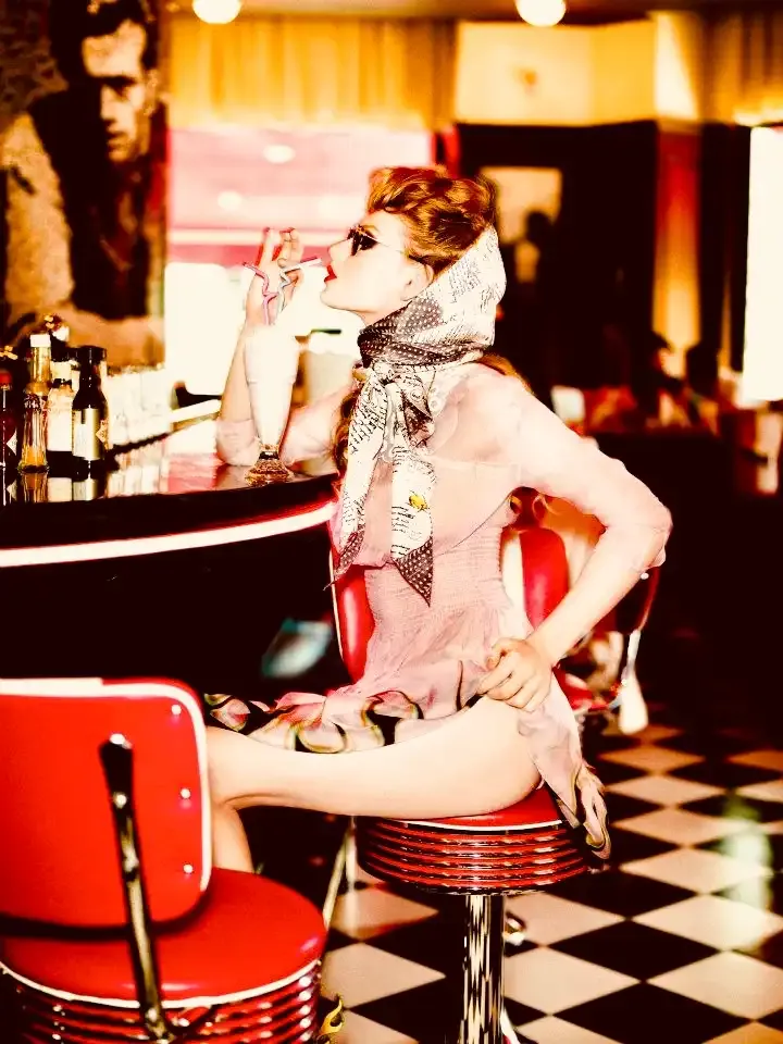 Modelka v retro šátku pije milkshake u baru dineru