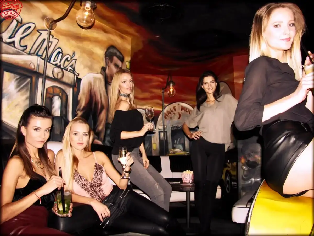 Pět žen s drinky v salonku Music Clubu před malbou Jamese Deana
